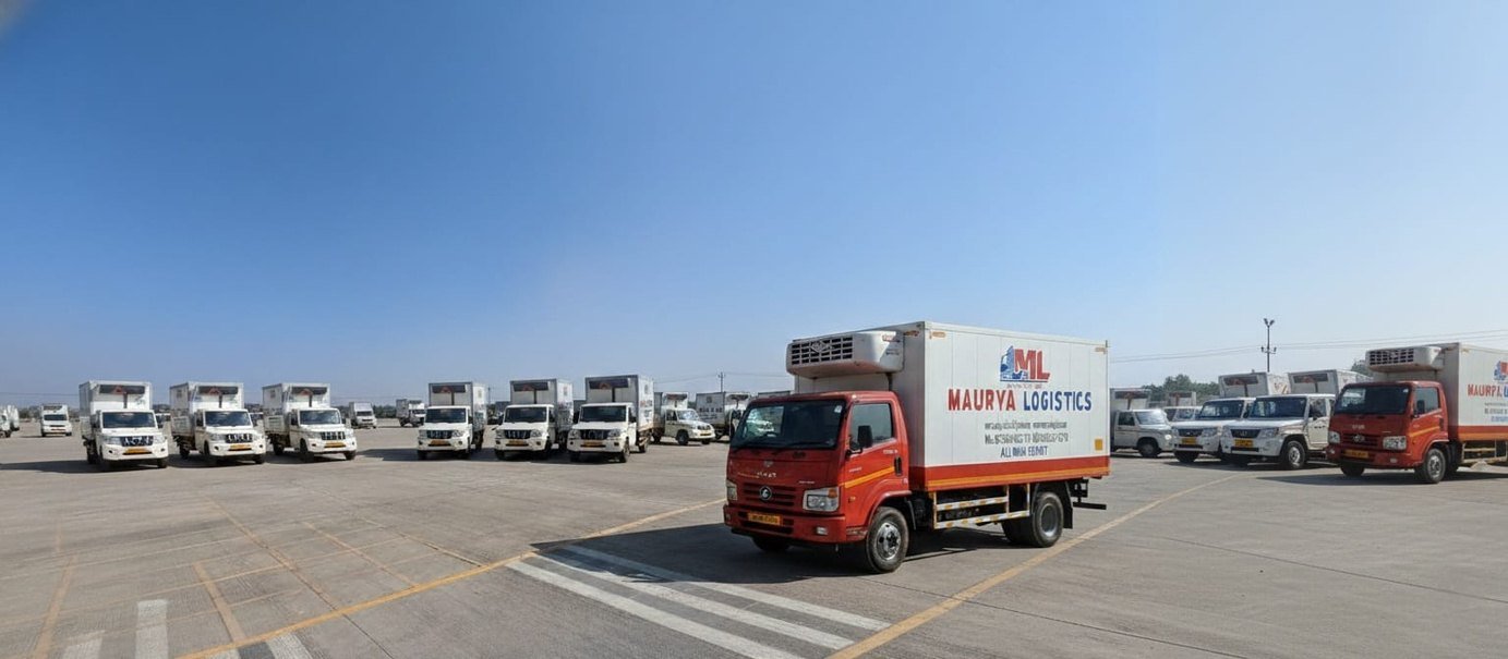 Row of Maurya Logistics refrigerated vehicles parked in the yard