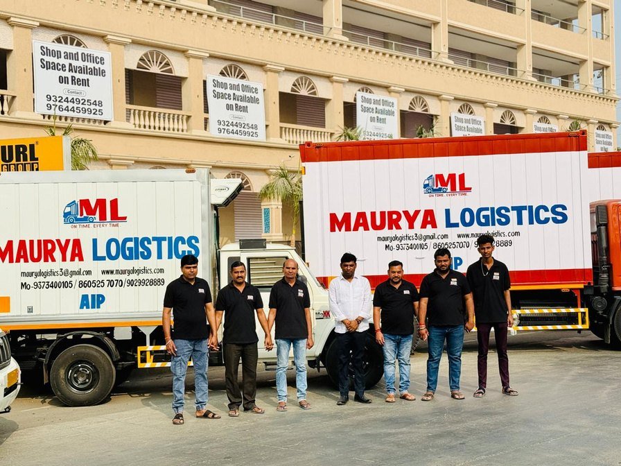 The Maurya Logistics operations team in front of two branded reefer vehicles
